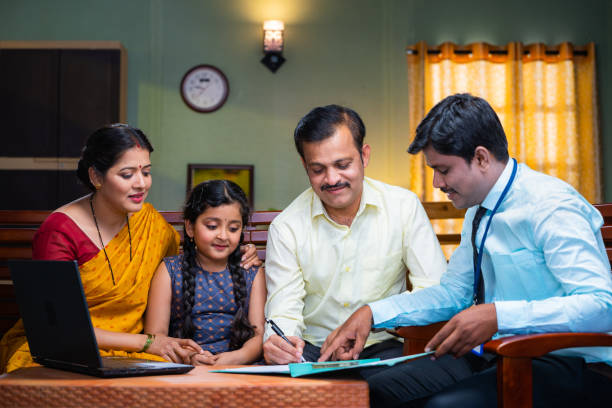 Bank officer taking sign from couple for insurance documents at home - concept of future investment, financial and agreement